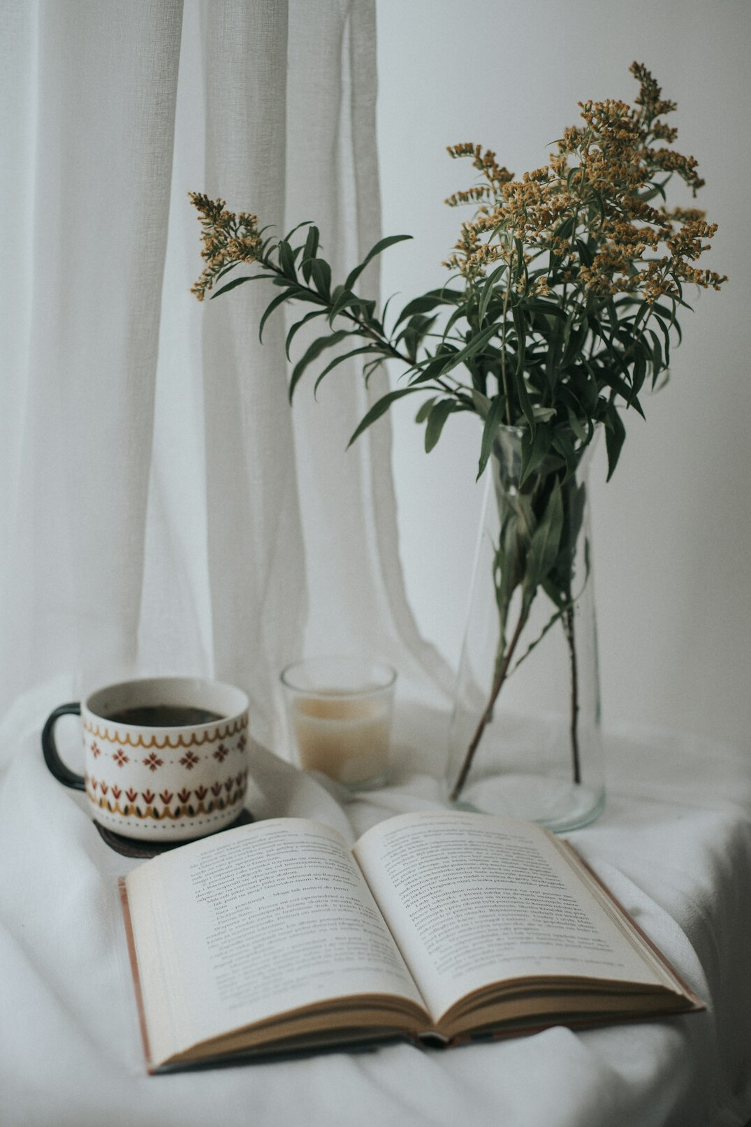 Open book with a coffee cup on a table